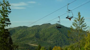 Kayak merkezinde teleferik. Boş bir kayak asansörü, yüksek Karpat Dağları manzarası, yaz güneşli doğa manzarası. Yüksek kalite 4k görüntü