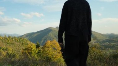 Dağların tepesinde el kaldıran kadın gezgin. Mutlu kız dağa tırmanmaktan hoşlanıyor. Uçuruma tırmanma tutkusu konsepti. Yüksek kalite 4k görüntü