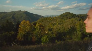 Dağ manzarasının tadını çıkaran mutlu genç bir kadın. Dişi maceracı tepenin zirvesine çıktıktan sonra manzaralı doğa manzarası düşünür. Yüksek kalite 4k görüntü