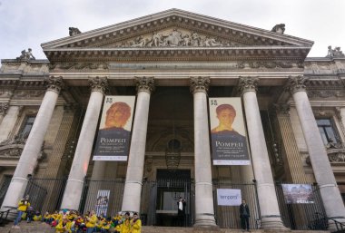 Brüksel borsası neo-rönesans mimari tarzı ön cephede güneşli bir günde merdivenlerde bir grup turistle