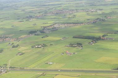 Güneşli bir günde bir uçaktan çekilmiş güzel yeşil Hollanda kırsal hava görüntüsü.
