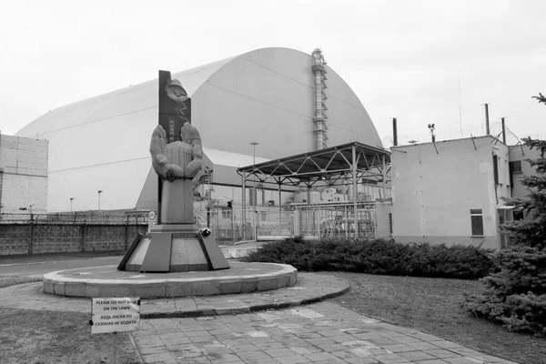 切尔诺贝利核电站爆炸现场第四反应堆大圆顶容器前的切尔诺贝利清盘人纪念碑 黑白摄影 — 图库照片