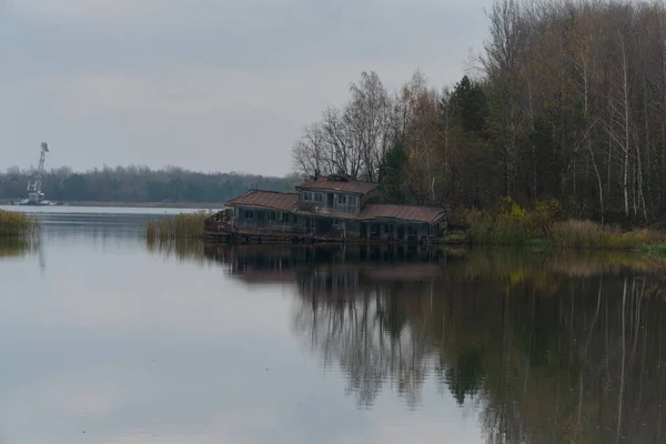 プリピャット ラスティ秋の森と灰色の曇りの空を背景にボートハウスを破壊 — ストック写真