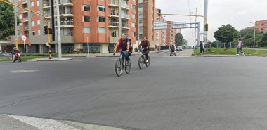 147. Cadde 'de bisiklete binen iki adam Bogota' da 9. caddenin köşesinde araba günü yok.