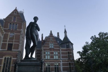 Rijksmuseum önünde gün batımının mavi olduğu güzel bir kadın heykeli