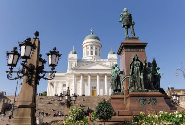 Helsinki Senato Meydanı 'nda Alexander II anıtı ve arka planda ulusal katedral ile güneşli mavi gökyüzü günü