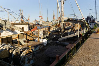 Güneşli günbatımında Helsinki limanında terk edilmiş bir balıkçı teknesi.