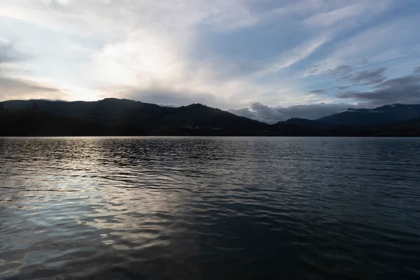 stock image Beautiful colombian lake and mountain range landscape in colorful sunset with water reflection effect and mountains silhouette