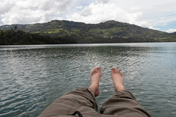 Vista Primeira Pessoa Uma Perna Masculina Sobre Lago Azul Com — Fotografia de Stock