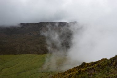 Beautiful colombian paramo andean mountains landscape with a grass valley and a big cloud arriving