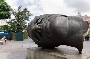 Pazar meydanında Eros Bendato Dev heykel 