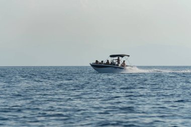 Güneşli bir günde Akdeniz 'de hızlı bir tekneye binen bir aile.