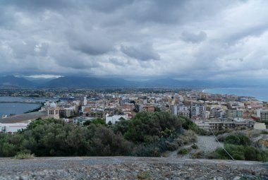 Milazzo şehrinin panoramik alacakaranlık manzarası. Arka planda bulutlu gökyüzü ve messina dağları olan milazzo kalesi manzaralı.