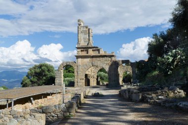 Sicilya Tindari arkeoloji parkı kalıntıları. Arka planda mavi gökyüzü olan bazilika olarak bilinen bir yapı.
