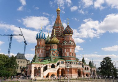 Saint Basils Ortodoks Kilisesi, arka planda mavi bulutlu yaz gökyüzü bulunan kırmızı meydanda yer almaktadır.