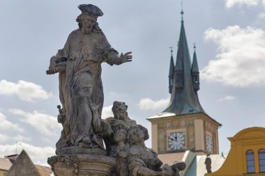 Güneşli bir günde, arka planda Prag Kalesi saati olan Kermartin Barok heykelinin Ivo heykeli