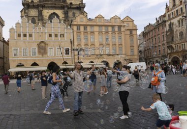 Bir adamın sabun köpüğü yaptığı ve çocukların Tyn Kilisesi 'nin önünde oynadığı güzel bir sahne. 