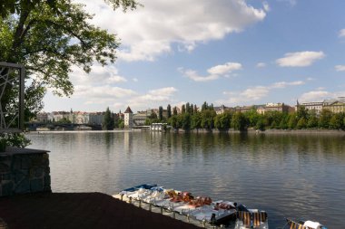 Vatlava Nehri Günbatımı manzarası. Arka planda turistik binalar var.