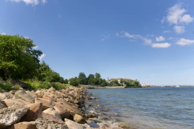 Güneşli bir günde arka planda Baltık Denizi ve eski şehir ile güzel Tallinn Estonya şehri kayalık kıyıları 