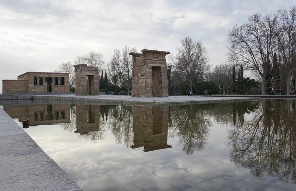 stock image Beautiful autumn scene of debod temple with watter reflections and cloudy sky at background