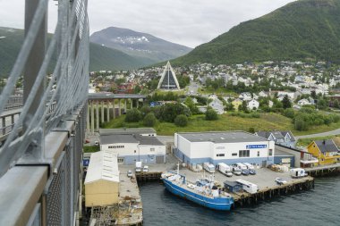 Tromso şehri güneşli bir günde kutup katedrali ve evleri olan bir Troms Köprüsü 'nden izleniyor.