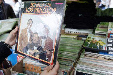 Bit pazarına kullanılmış vinil taşıyan bir kadının ellerine yakın.