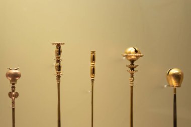 Altın müzenin çubuğunun tepesinde altın parçaları olan yerel ahşap bir poporo sopasına yakın.