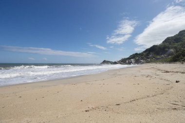 Kimsesiz Karayip sahilleri, arka planda orman dağları olan Kolombiya Tayrona Ulusal Parkı 'na