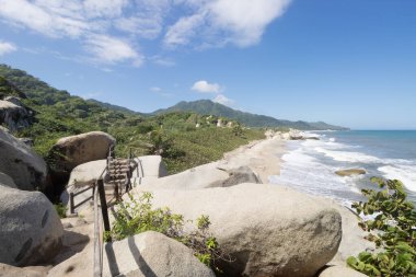 Tayrona Milli Parkı 'nın güzel güneşli manzarası. Arka planda yürüyüş merdivenleri ve Sierra Nevada sıradağları var.