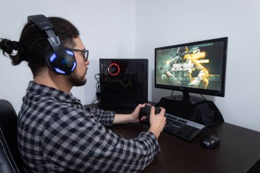 Young man playing call of duty black ops six on a modern gamer computer clipart