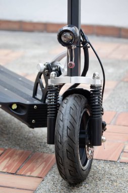 Arka planda bulanıklık olan modern elektrikli scooter 'a yakın park yeri.