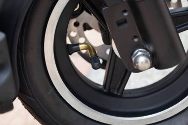 Güneşli bir günde kapakçık ve jantla elektrikli scooter 'a yakın.