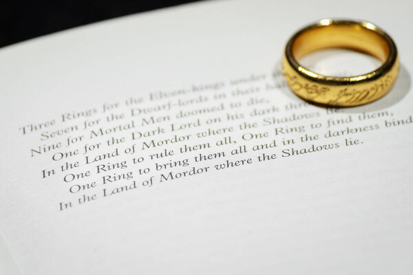 Selective focus of famous phrase of the lord of the rings english text book with sauron's ring on 