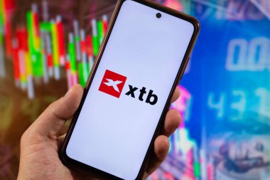 BOGOTA, COLOMBIA - 05 Mart 2025 Xtb borsa hizmet logosuna sahip bir akıllı telefon ve arka planda bulanık finans kavramı