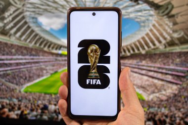 BOGOTA, COLOMBIA - 05 Mart 2025 Fifa dünya kupası logosuna sahip bir akıllı telefon arka planda beyaz bir arka grup ve bulanık bir stadyum