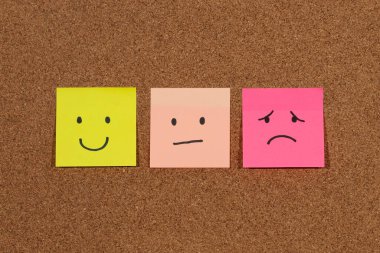 Mantar arkaplan üzerinde insan duygularını yansıtan üç yapışkan notaya yaklaş