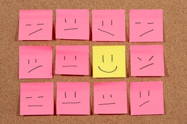 Mutlu bir hayatı temsil eden bir grup yapışkan nota yakın bir mantar arka planda bir sürü kızgın yüzle çevrili.