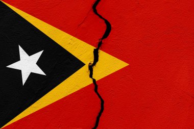 Timor-Leste ya da Doğu Timor Demokratik Cumhuriyeti bayrağı bir grunge çatlağı duvarına saplandı. Jeopolitik ve doğal afet kavramı