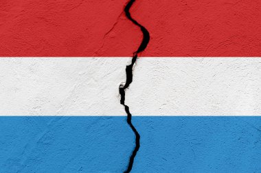 Lüksemburg Büyük Dükalığının bayrağı bir grunge çatlağının duvarına saplandı. Jeopolitik ve doğal afet kavramı