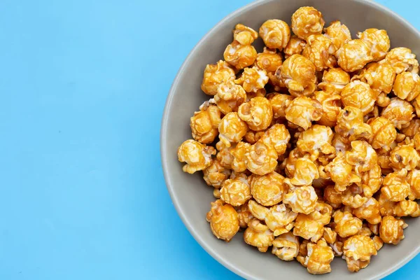 Honey caramel popcorn on blue background.