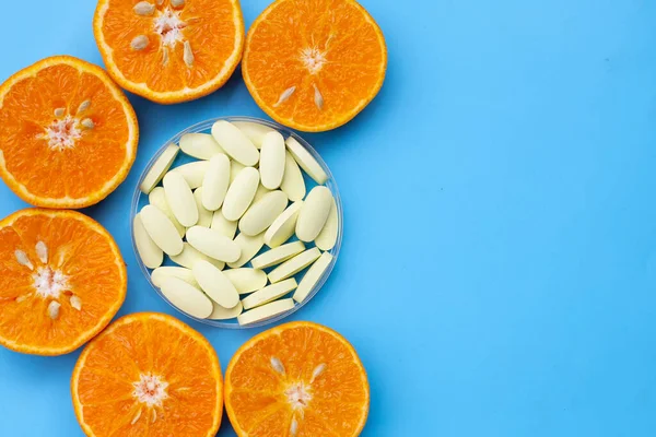 Vitamin C pills with  fresh orange citrus fruit