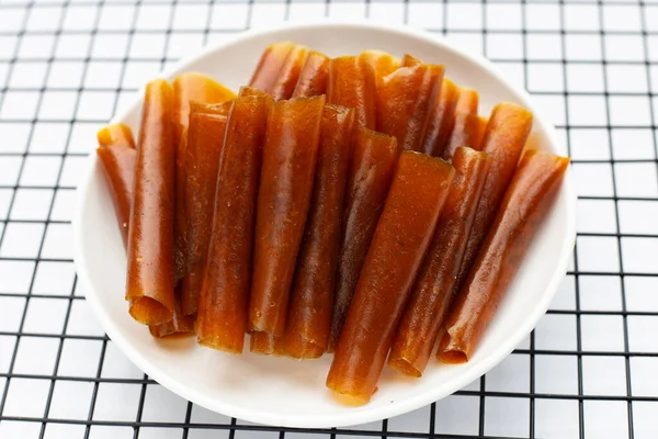 Dried mango paste sheets on white background.