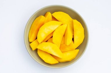 Beyaz arkaplanda sarı mango dilimleri.