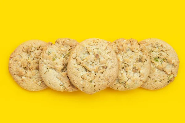 Pistachio and almond cookies on yellow background.