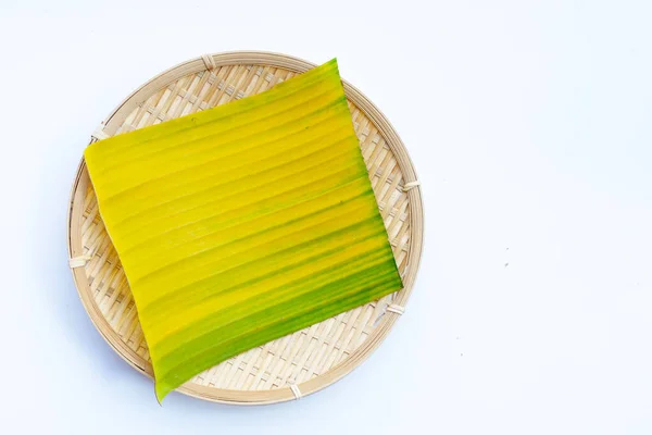 白底竹织盘中的黄绿色香蕉叶 — 图库照片