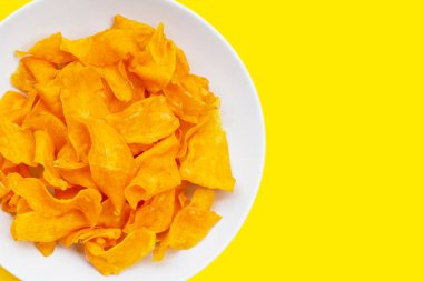 Sarı arka planda tatlı patates cipsi.
