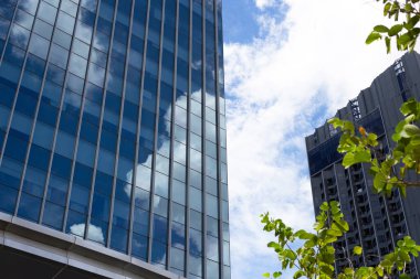 Mavi gökyüzünün yansıması ve cam bina üzerindeki bulut