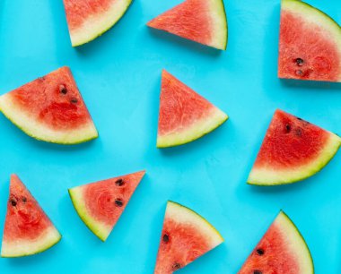 Mavi arka planda dilimlenmiş karpuz, üst manzara.