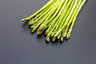 koyu arka plan üzerinde taze kuşkonmaz.