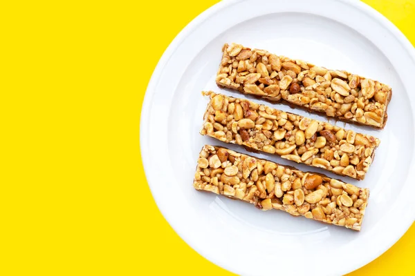 Peanuts butter chocolate bars on yellow background.